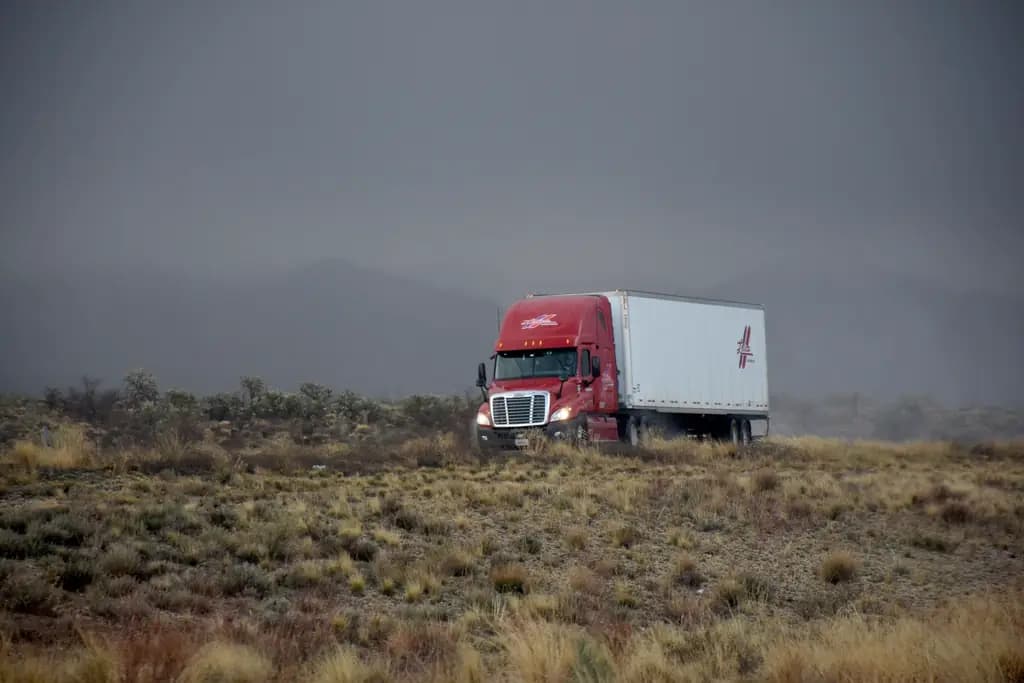 An articulated lorry on an open highway under a heavy sky