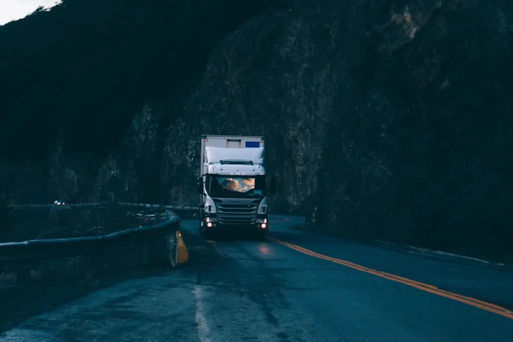 A truck descending a mountain pass in the blue light after sunset